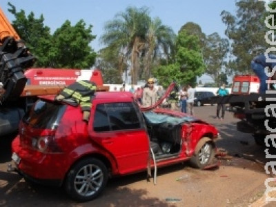 Golf vai parar embaixo de caminhão e passageira fica presa às ferragens