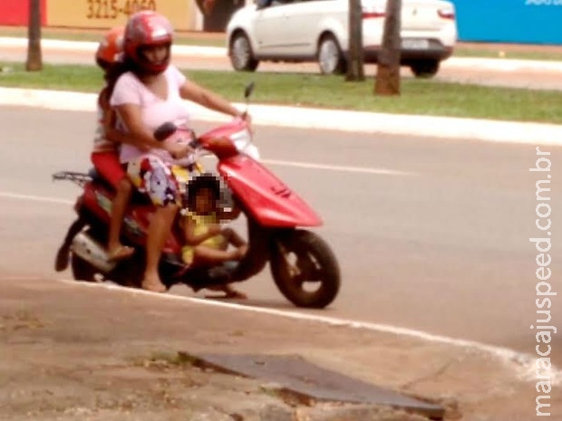 Menina é transportada entre as pernas de motociclista