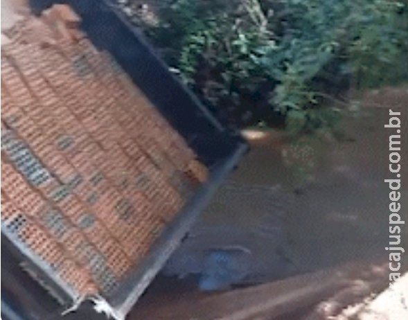 Ponte de madeira desaba e caminhão com areia e tijolos fica pendurado em Aquidauana